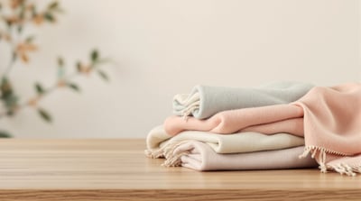 A soft wool scarf folded on bare wood, a close view